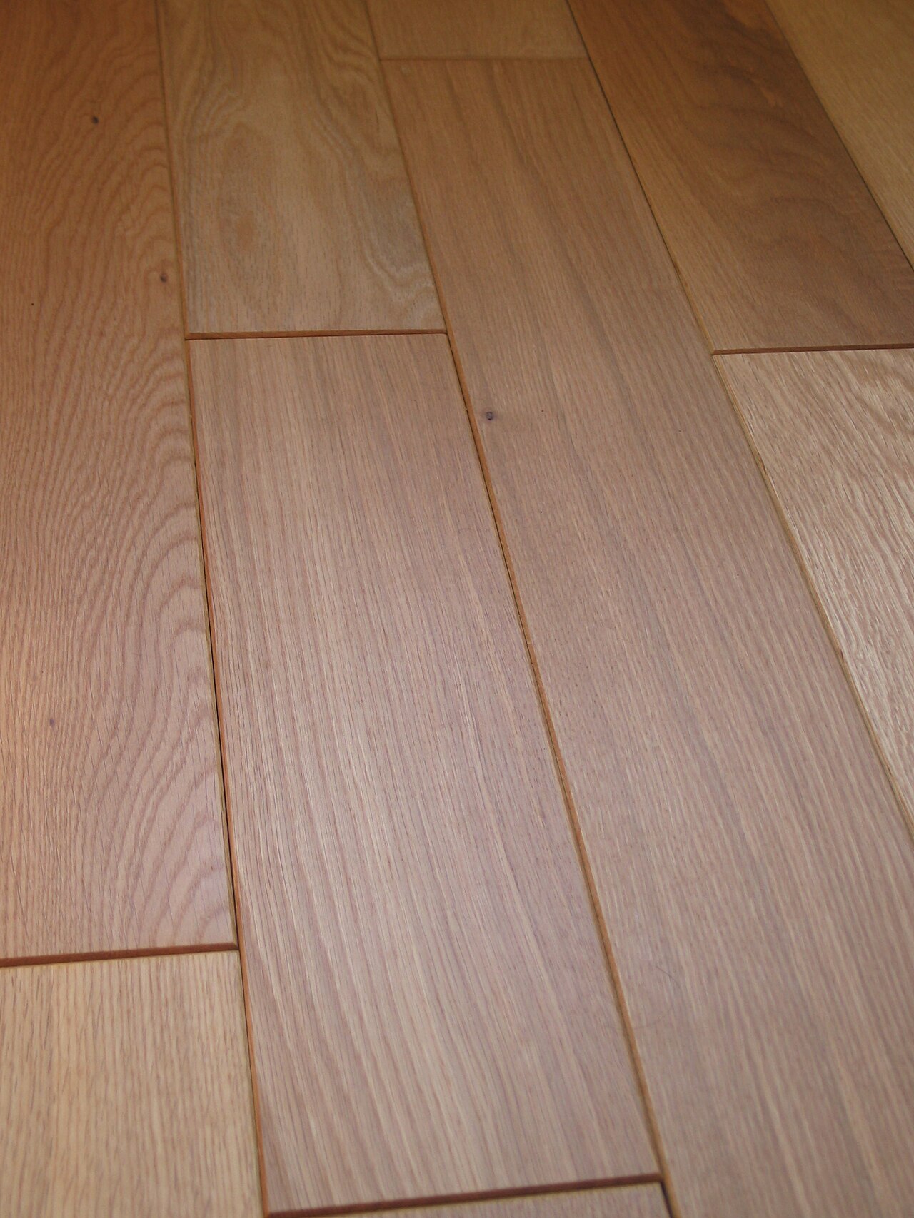 Photographie rapprochée de joints et chanfreins entre lames de parquet massif en chêne